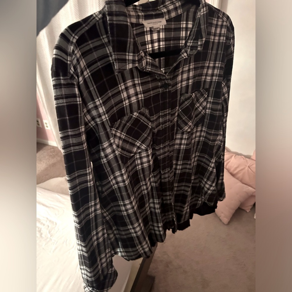 A flannel type shirt with a black part that comes down in the back.